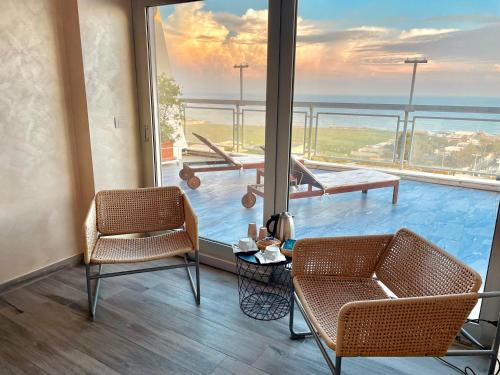 a room with two chairs and a view of the ocean at Barion Hotel & Congressi in Bari