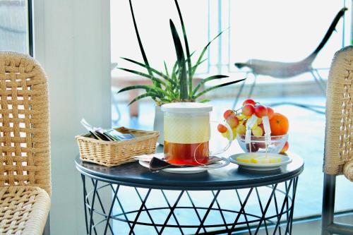 a table with a drink and a basket of fruit at Barion Hotel & Congressi in Bari