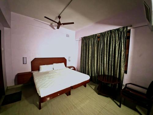 a bedroom with a bed and a ceiling fan at Hotel Blue Residency in Nāgercoil