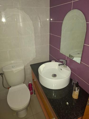 a bathroom with a white toilet and a sink at Brisa Mar Apartamento in Praia Baixo