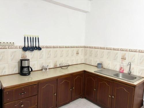a kitchen with a sink and a counter top at Residence Ville Noire in Mahébourg