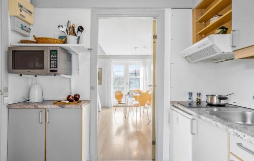 a kitchen with white cabinets and a microwave at Awesome Apartment In Allinge With Wifi in Allinge