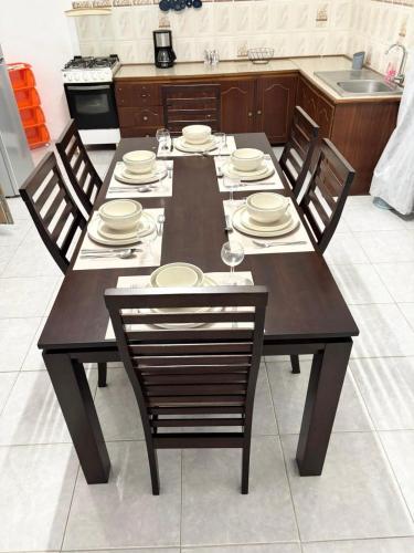 a dining room table with chairs and plates on it at Residence Ville Noire in Mahébourg