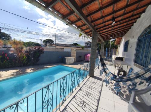a swimming pool on a balcony with a hammock at Casa da cama elástica - Alto da Boa vista - 3 quartos in Araruama