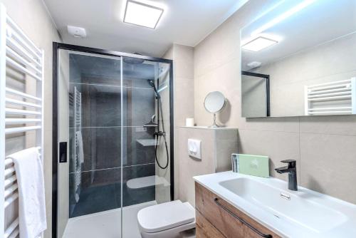une salle de bain avec une douche, un lavabo et des toilettes dans l'établissement Fermes du Planet, à Morzine