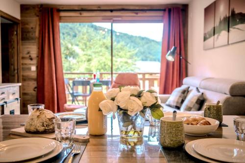 une table de salle à manger avec un vase de fleurs dessus dans l'établissement Fermes du Planet, à Morzine