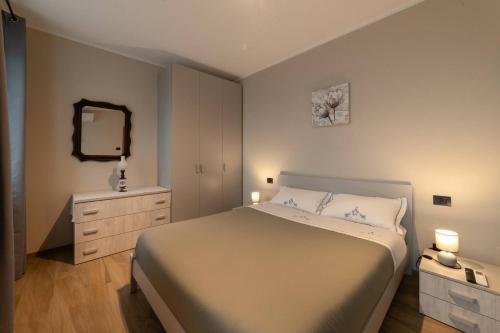 a bedroom with a bed and a dresser and a mirror at Casa Rubbo - Appartamento in collina 'Monviso' in Alba