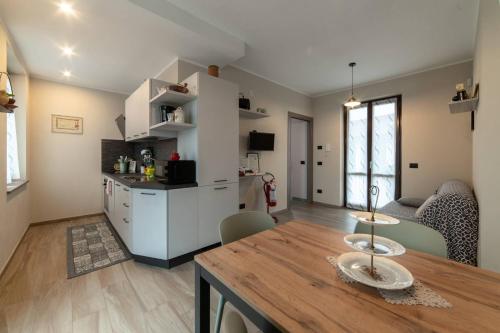 a kitchen and living room with a wooden table and a dining room at Casa Rubbo - Appartamento in collina 'Monviso' in Alba