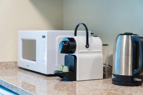 a coffee maker sitting next to a microwave on a counter at Amazing apartment in JLT Cluster C in Dubai