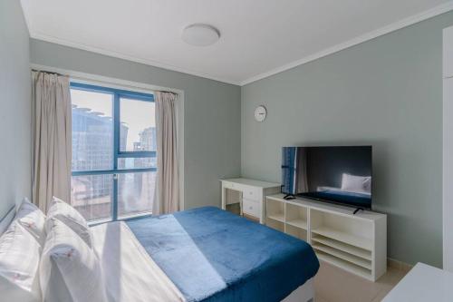 a bedroom with a bed and a desk and a window at Amazing apartment in JLT Cluster C in Dubai