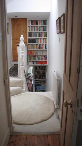 a hallway with a book shelf with books at Holmewood Homestay in London