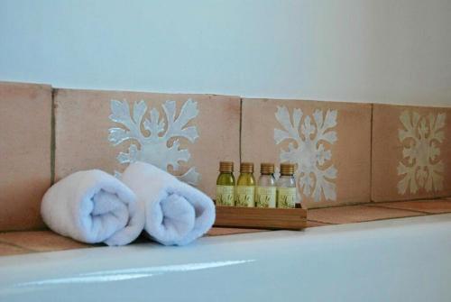 a pair of towels and bottles of oils on a tub at Cortijo de Vega Grande in Llerena
