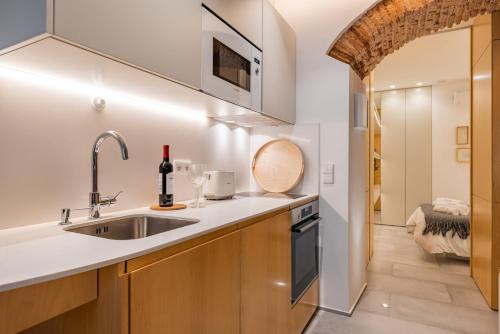 a kitchen with wooden cabinets and a sink at Condessa Heaven RC in Lisbon