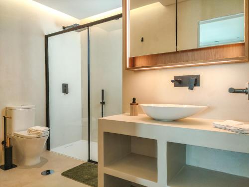 ein Badezimmer mit einem weißen Waschbecken und einer Dusche in der Unterkunft Villa Esperança in Porches