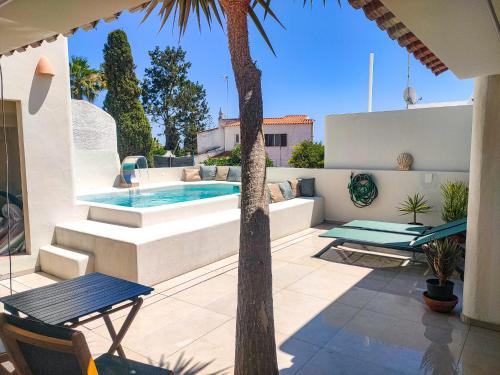 a patio with a swimming pool and a palm tree at Villa Esperança in Porches