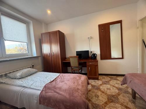 a bedroom with a bed and a desk and a mirror at OŚRODEK WYPOCZYNKOWY MAZOWSZE W KARPACZ in Karpacz