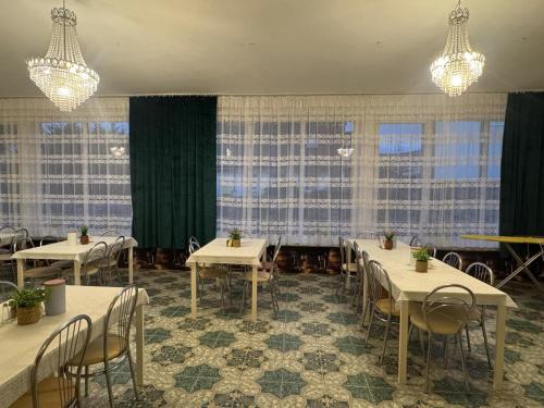 a dining room with tables and chairs and windows at OŚRODEK WYPOCZYNKOWY MAZOWSZE W KARPACZ in Karpacz