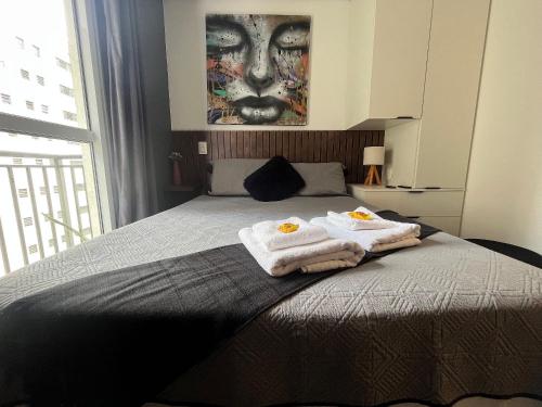 Un dormitorio con una cama con toallas. en Studio próximo ao teatro Renault e hospitais, en São Paulo