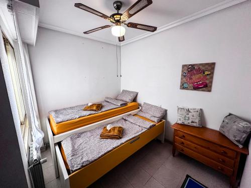 two beds in a room with a ceiling fan at La Mata dream in La Mata