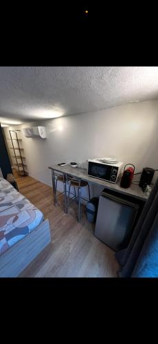 a room with a desk and a table with a microwave at Beau studio dans le centre de Bourges historique ! in Bourges