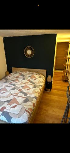 a bedroom with a bed with a clock on the wall at Beau studio dans le centre de Bourges historique ! in Bourges