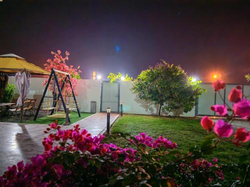 a playground at night with pink flowers at Highness Villa Nizwa in Nizwa
