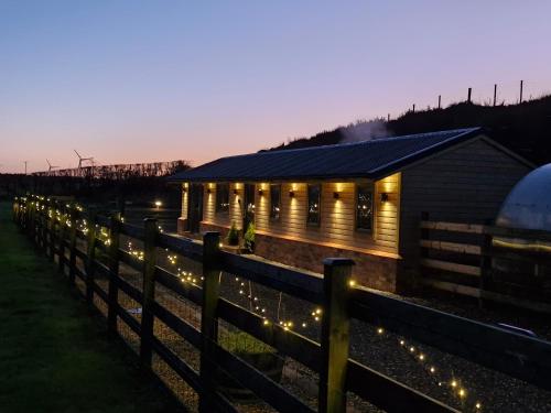 a building with lights in front of a fence at Cozies Cabin in Billy