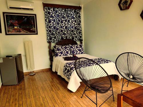 a bedroom with a bed and a fan at Tico Bed & Breakfast La Fortuna in Fortuna