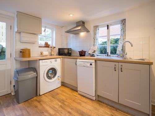 a kitchen with a washing machine and a washer at Pass the Keys Cosy cottage hideaway set in beautiful countryside in Hopesay