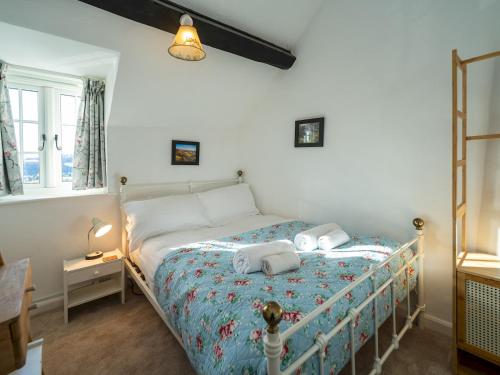 a bedroom with a bed with two towels on it at Pass the Keys Cosy cottage hideaway set in beautiful countryside in Hopesay
