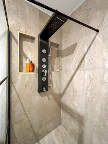 une douche dans une salle de bain avec une porte vitrée dans l'établissement Maison avec Terrasse proche Gare pour Paris et Disneyland - 6 personnes, à Gagny