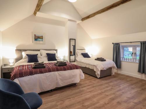Un dormitorio con dos camas y una silla. en Merddwr, en Corwen