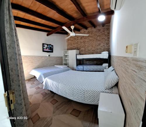 a bedroom with two beds and a brick wall at Granados in Asuncion