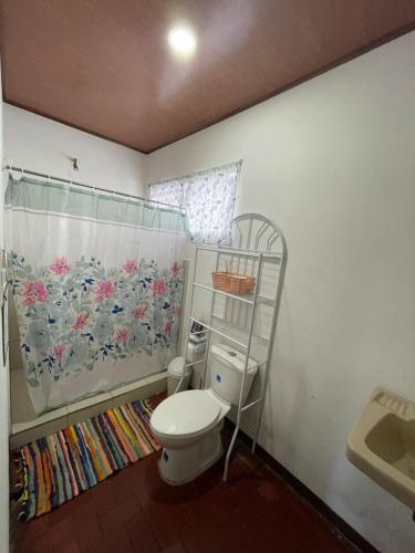 a bathroom with a toilet and a shower curtain at Hostel Casa Mar in Liberia