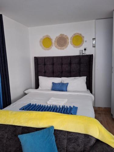a bedroom with a large bed with blue and yellow sheets at Lymak Studio airbnb in Ongata Rongai 
