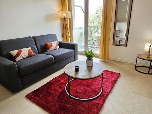 a living room with a couch and a table at Agréable Studio - Centre ville - Balcon in Toulouse