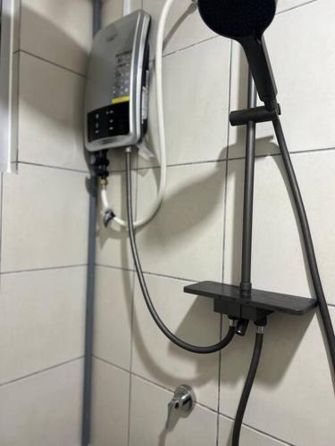 un teléfono colgado en una pared en un baño en Kajang MRT suites, en Kajang