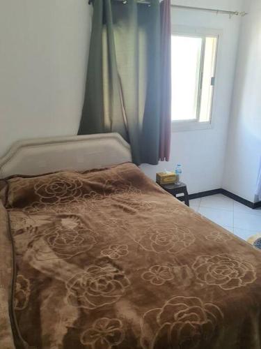 a bed with a brown comforter in a bedroom at Good choice peace your mind in Sharjah