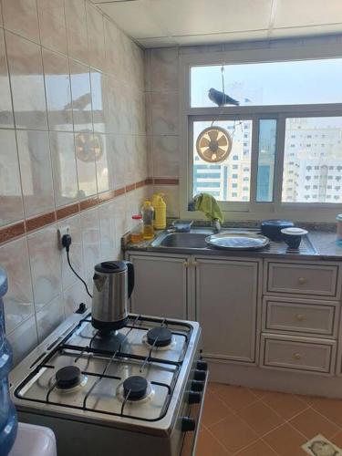 a kitchen with a stove with a pot on it at Good choice peace your mind in Sharjah