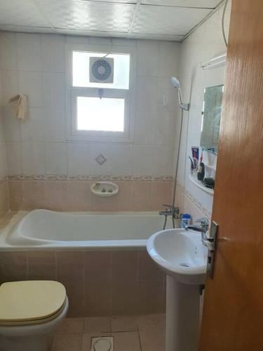 a bathroom with a tub and a sink and a toilet at Good choice peace your mind in Sharjah