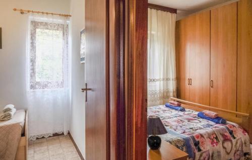a small bedroom with a bed and a window at Stunning Apartment In Sangineto in Sangineto
