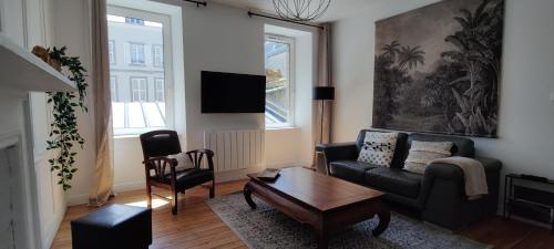 a living room with a couch and a table at Le Corsaire in Granville
