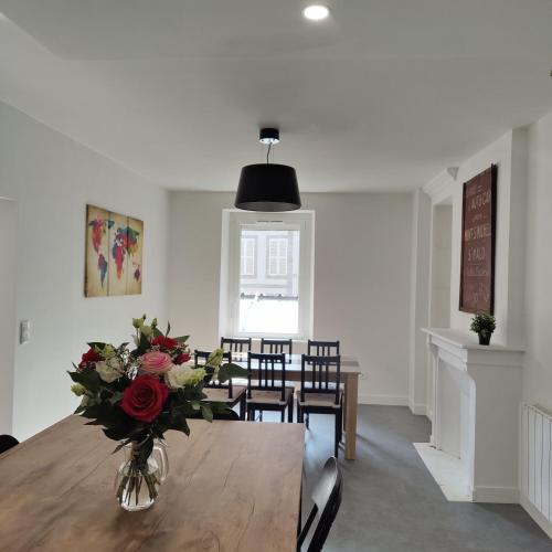 une salle à manger avec un vase de fleurs sur une table dans l'établissement Le Corsaire, à Granville