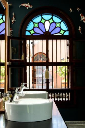 La salle de bains est pourvue d'un lavabo blanc et d'un vitrail. dans l'établissement Vasco de Gama - Villa d'architecte de luxe avec piscine & spa, à Sarlat-la-Canéda