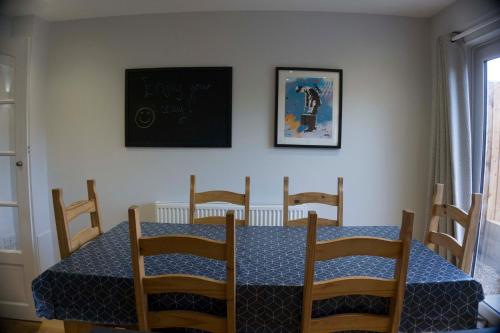 a dining room table with chairs and a chalkboard on the wall at Entire 3-bed house near Cheltenham racecourse and town in Gloucestershire