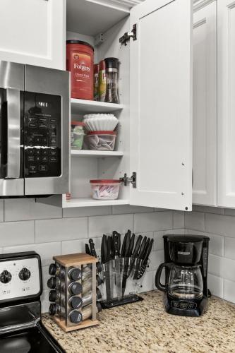 a kitchen with white cabinets and a counter top at Luxury 3B Mountain Views- Pool & Hot Tub -Sleeps 10 in Canmore