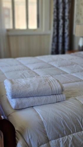 two towels sitting on top of a white bed at Hotel Boutique Domus Mare in Viña del Mar