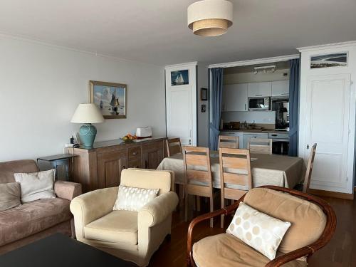 un salon avec un canapé et des chaises et une cuisine dans l'établissement Le Touquet magnifique appartement 3 chambres vue sur mer, à Le Touquet-Paris-Plage
