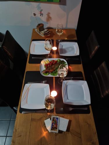 a table with wine glasses and a plate of food at Apartament exclusive Głuszyca in Głuszyca