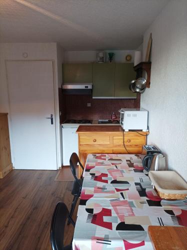 une cuisine avec une table avec un motif sur le sol dans l'établissement AI208 Studio 4 Pers Proche base de loisirs Carroz, aux Carroz d'Arâches